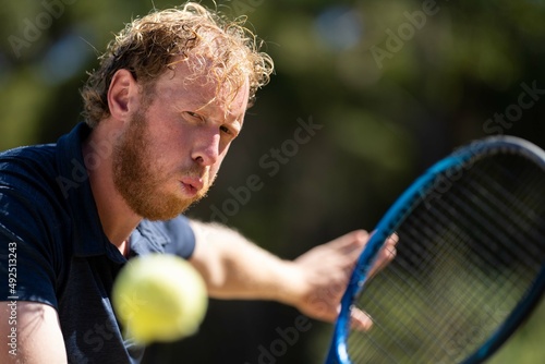 Amateur playing tennis in Melbourne, hobart, Sydney, Australia. stretched out reaching for the yellow ball.   © William