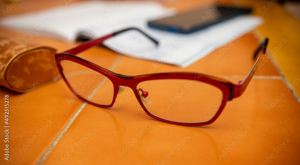 Glasses lie on the table, blurred background of the phone, laptop. Glasses lie on the table, blurred background of the phone, laptop.