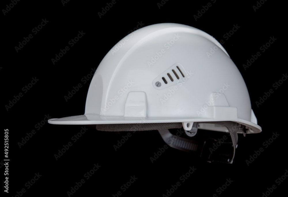 White construction helmet on a black background. White construction helmet on a black background.