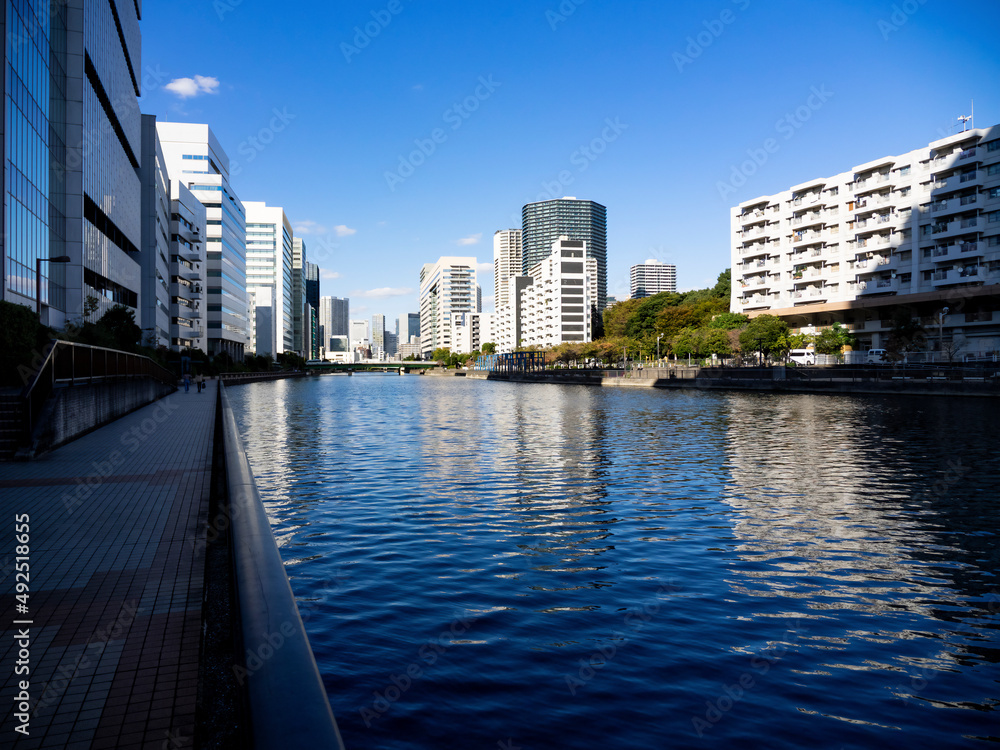 Fototapeta premium 東京の運河と近代的な建物群のある風景 