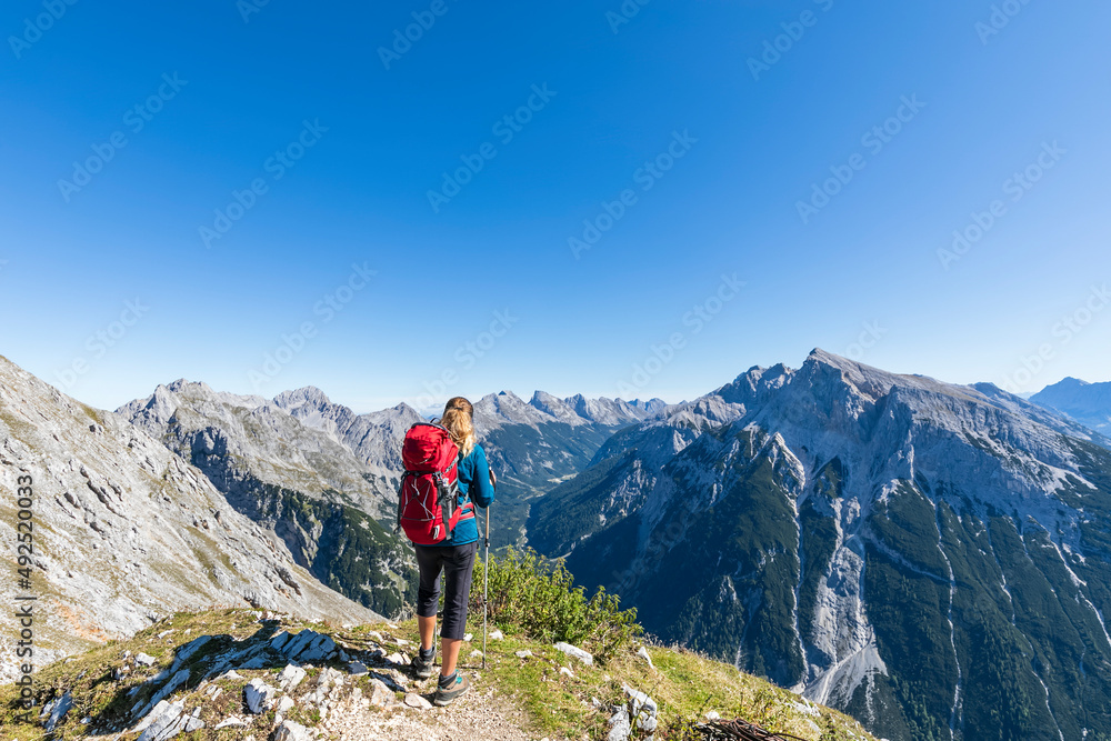 Female hiker admiring view of Mittenwalder Hohenweg in summer Female hiker admiring view of Mittenwalder Hohenweg in summer