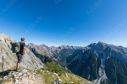 Male hiker admiring view of Mittenwalder Hohenweg in summer photo