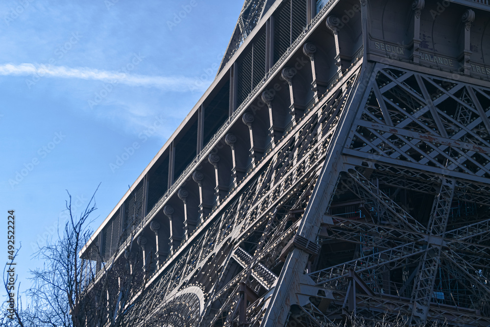Details of the structure of Eiffel Tower landmark building from Paris, France, in a sunny day