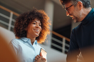 Happy business colleagues discussing in meeting at work place