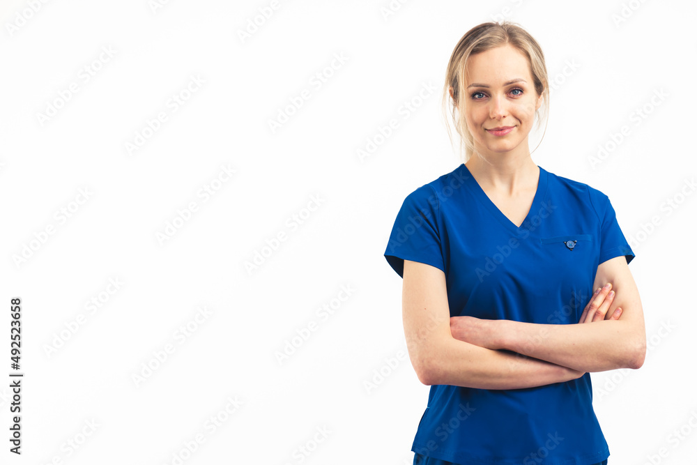 Positive blonde healthcare worker woman in dark blue uniform looking at camera and crossing her arms. Isolated medium studio shot. High quality photo Positive blonde healthcare worker woman in dark blue uniform looking at camera and crossing her arms. Isolated medium studio shot. High quality photo