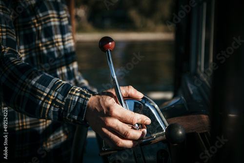 Hand of man controlling lever of boat photo
