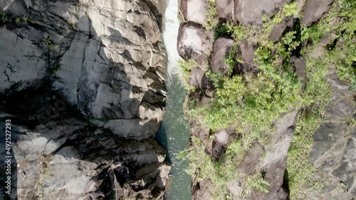 DRONE AERIAL SHOT IN WATERFALL SURROUNDED BY TREES AND ROCKS photo