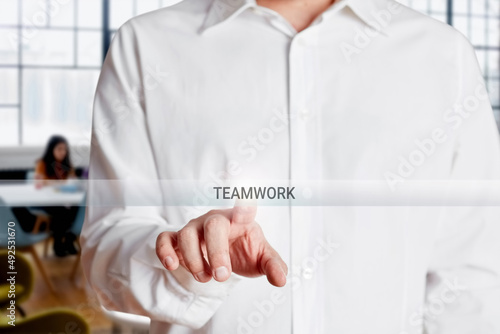 Businessman hand presses teamwork button on a virtual touch screen. Business team, collaboration or teamwork
