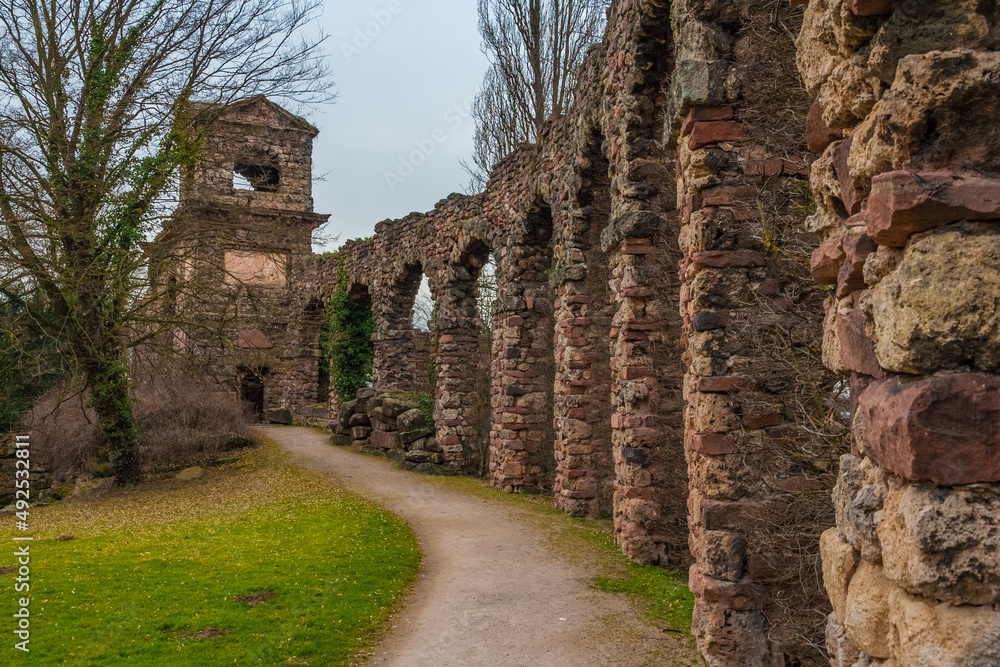The walkway along the artificial ruins of the Roman aqueduct, leading to the likewise artificial ruins of a Roman water fort in the English landscape garden of the famous Schwetzingen Palace.