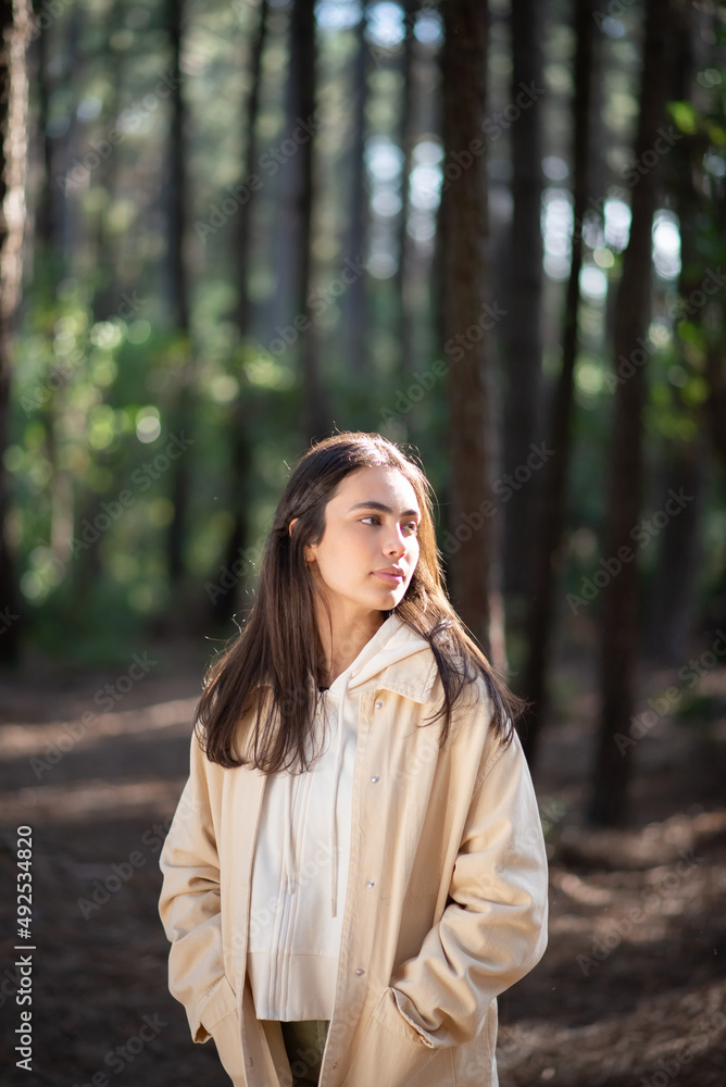 Portrait of attractive young woman in forest. Caucasian female woman with dark hair and green eyes looking sideways. Portrait, nature, beauty concept Portrait of attractive young woman in forest. Caucasian female woman with dark hair and green eyes looking sideways. Portrait, nature, beauty concept