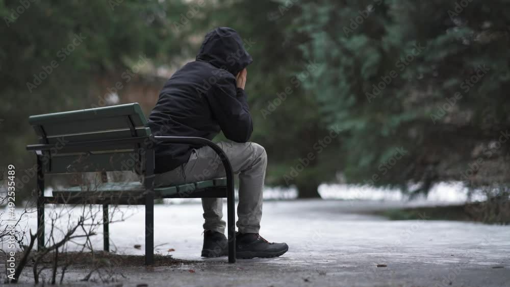 Man sitting on a bench and feeling lonely and depressed Man sitting on a bench and feeling lonely and depressed