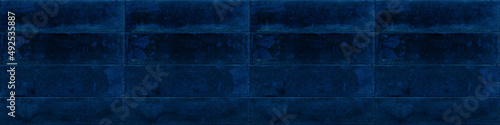 Dark blue rectangular rustic brick tiles wall or floor texture wide backgroun...