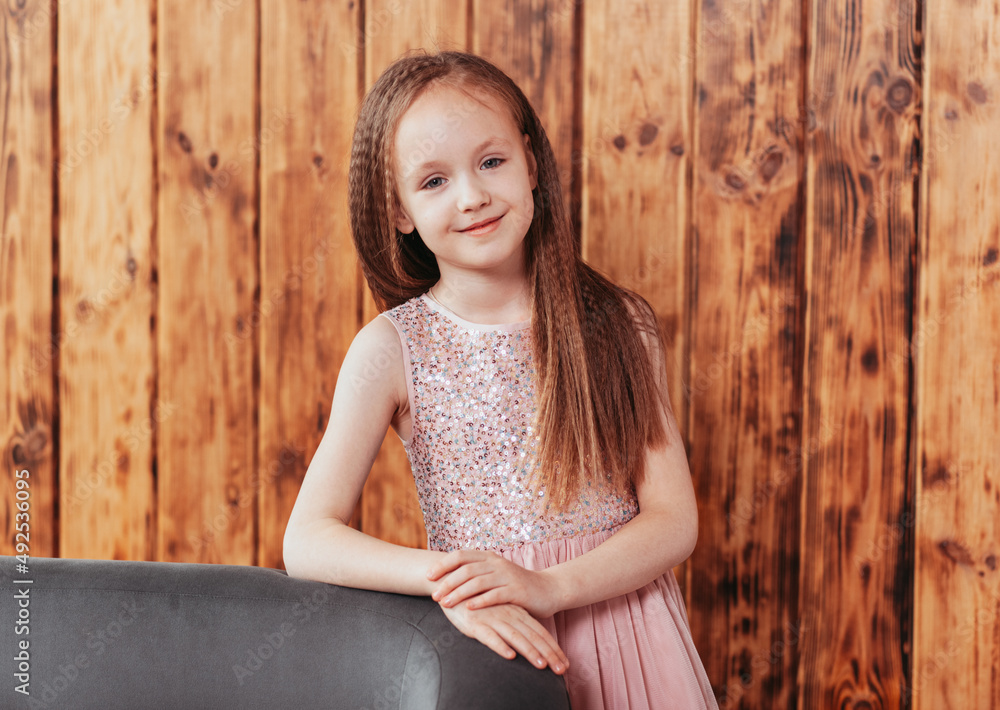 Fototapeta premium Smiling girl thinking looking at camera in room at home