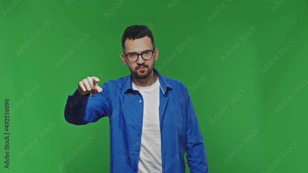 Positive man pointing finger to camera isolated over green background. Choice or selection concept Positive man pointing finger to camera isolated over green background. Choice or selection concept