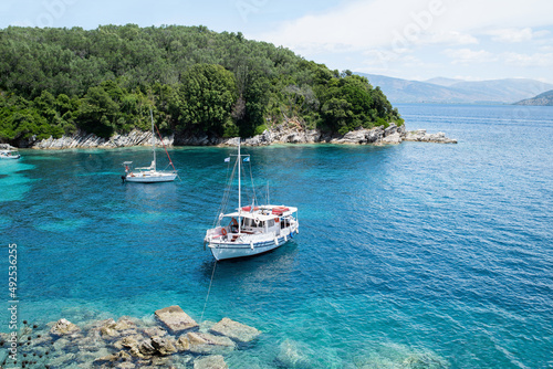 Corfu island, Greece, beautiful bay with a boat. Picturesque greek seascape. Yachting, travel, vacations, summer fun, enjoying life and active lifestyle concept