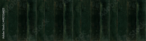 Dark green rectangular rustic brick tiles wall or floor texture wide background banner panorama © Corri Seizinger