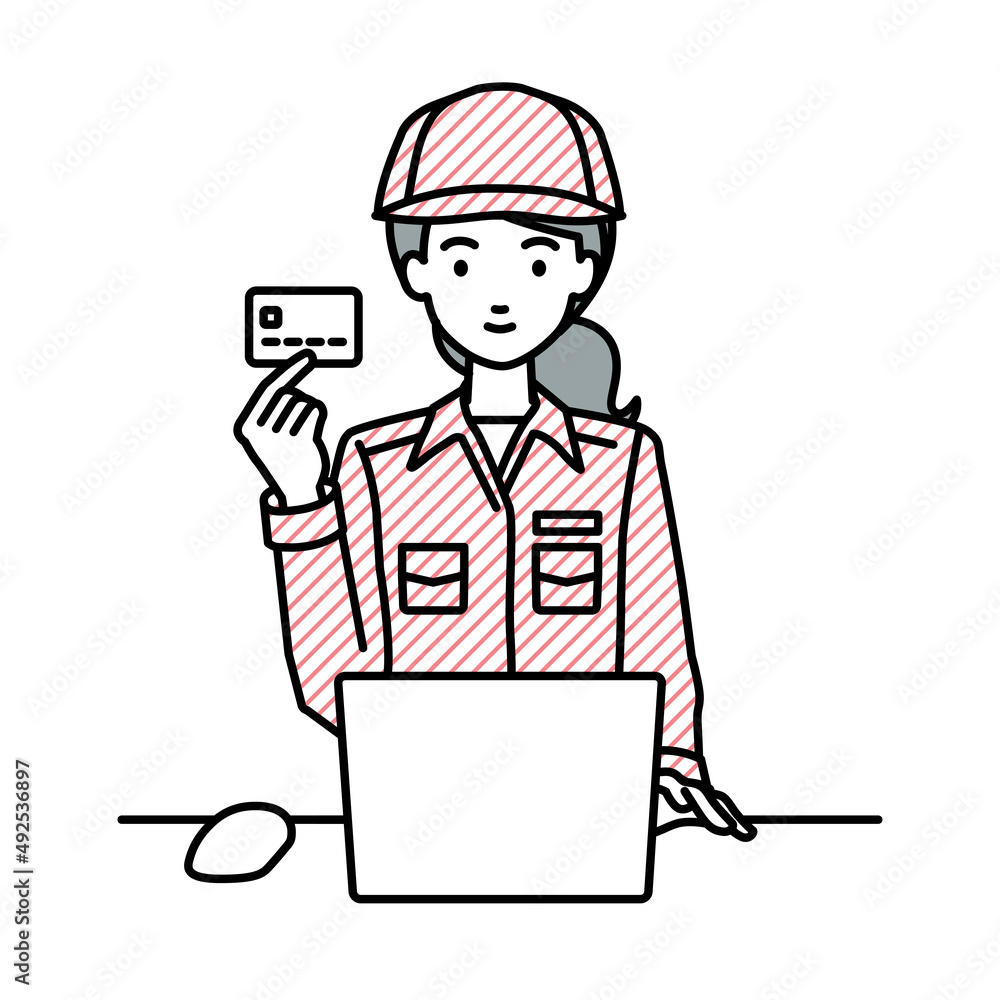 デスクで座ってPCを使いながらクレジットカードを手に持っている作業員の女性