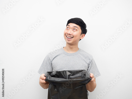 Man holding garbage smiling and looking above