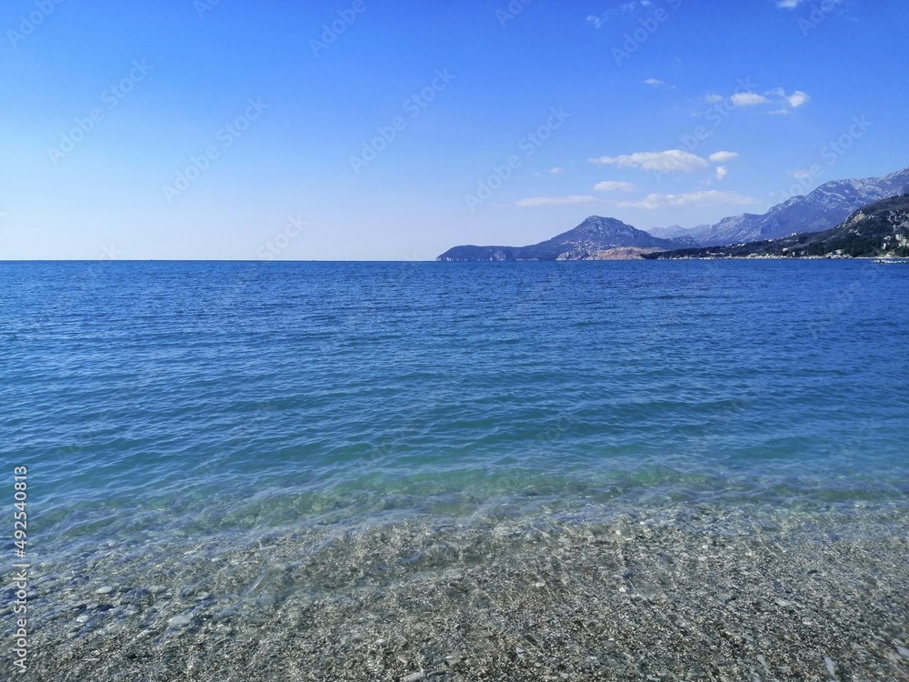 Blue, clear and beautiful sea with a view of the big mountains...Clear and blue sky with small clouds