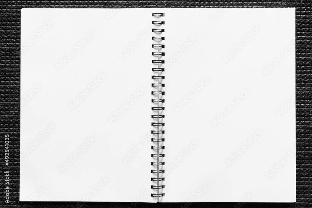 An open spring notebook with white sheets An open spring notebook with white sheets
