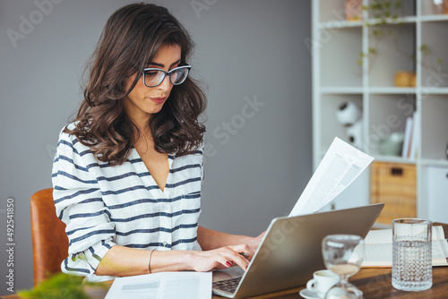 A business woman does banking and administrative work by keeping accounts at home. She counts money, pays bills online, a modern woman. The concept of finance and economics