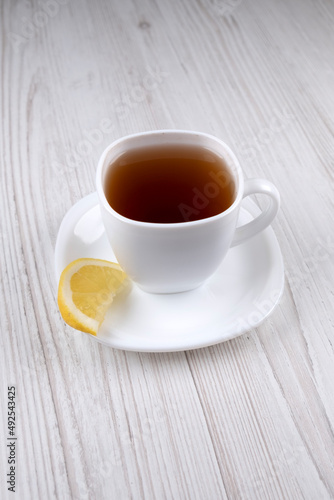 Tea with lemon. Tea in a white cup. A slice of lemon on a white saucer