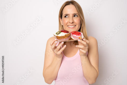 Image of happy woman in casual clothes holding piece of birthday cake isolated over white background. Celebration concept.
