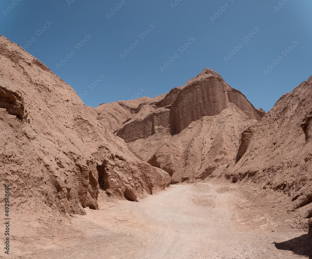 Hiking through the narrow desert trails of the Quebrada de Chulakao (aka., Devil’s Throat). Dramatic sand, dunes and rock formations. San Pedro de Atacama, Cordillera de la Sal. Chile
