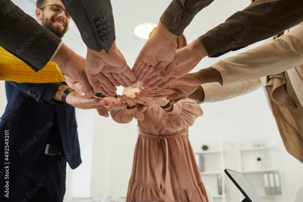 Φωτογραφία Happy diverse mixed race multiethnic business people join their hands as they gather together for a meeting in the office