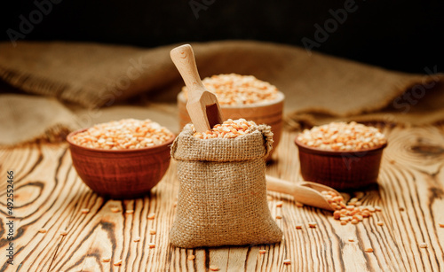 Pea groats in bowls and bags on a wooden background. High quality photo