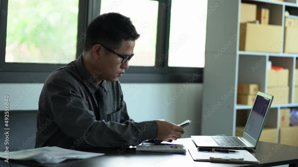 Successful cheering Asian men counting money celebrating victory with a lot of money. Young Asian businessman counting dollars on the table in room Successful cheering Asian men counting money celebrating victory with a lot of money. Young Asian businessman counting dollars on the table in room