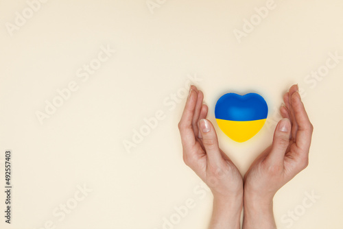 Heart with print the national flag of ukraine in female hand. Flat lay.