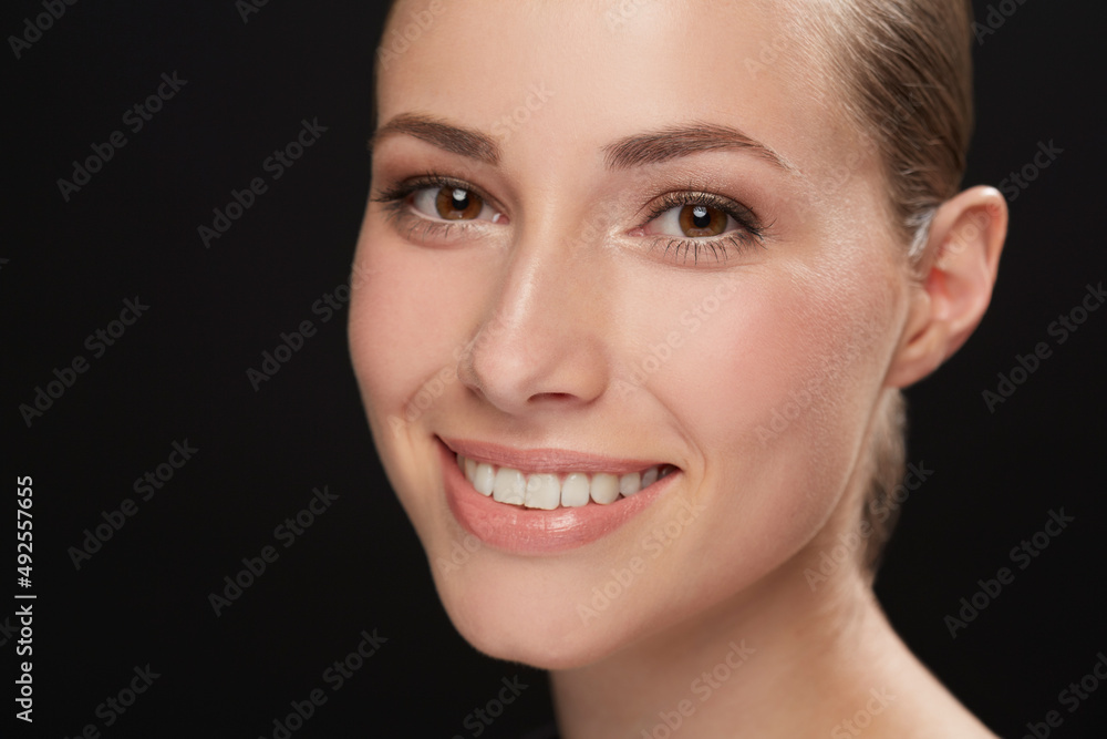 Natural brunette beauty. Cropped view of a naturally beautiful young brunette smiling against a black background. Natural brunette beauty. Cropped view of a naturally beautiful young brunette smiling against a black background.