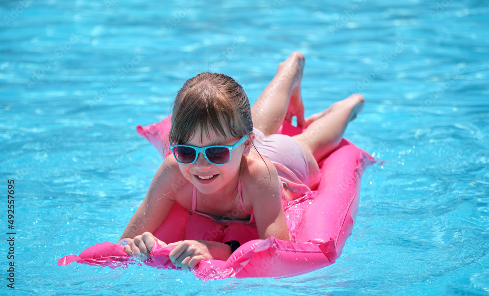 Young child girl relaxing on summer sun swimming on inflatable air