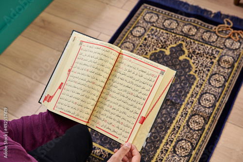 Man read Koran in the home, close up, praying.