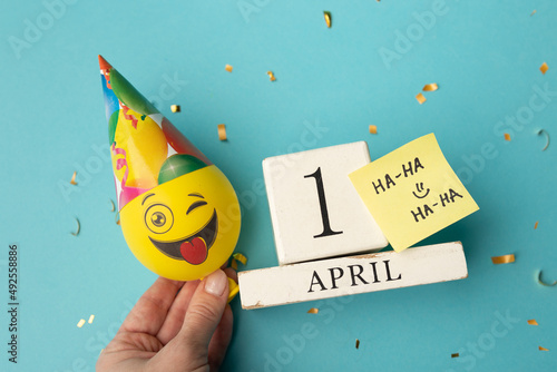 April 1st. Image of april 1 wooden calendar and festive decor on the blue background. April Fool's Day