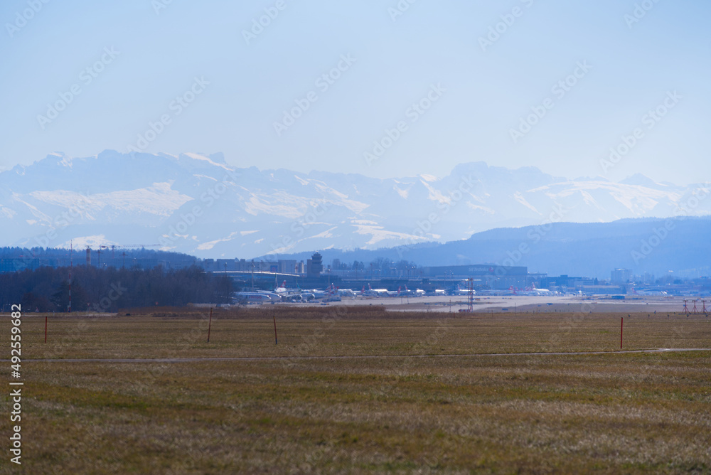 Scenic landscape with Swiss Alps in the background seen from Zürich Airport on a cloudy winter day. Photo taken February 24th, 2022, Zurich, Switzerland.