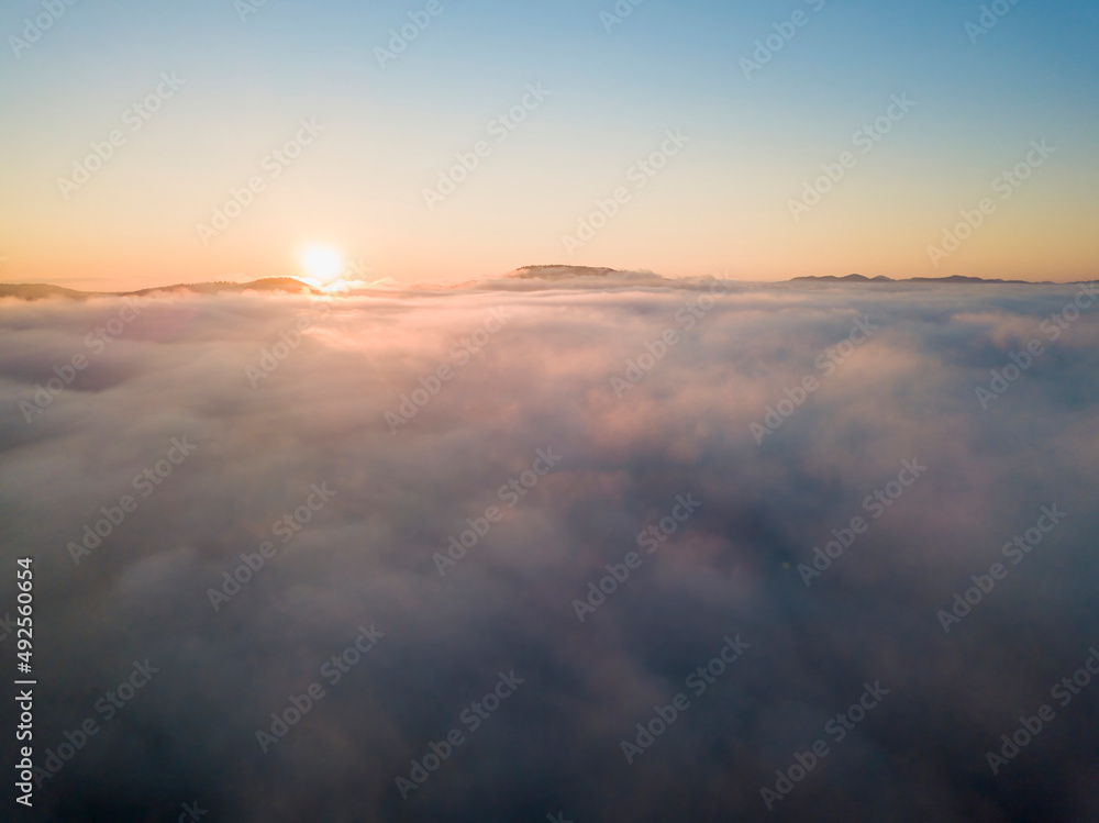 Sunrise over the fog in the Ukrainian Carpathians. Aerial drone view.