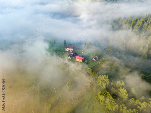 Mountain settlement in the Ukrainian Carpathians in the morning mist. Aerial drone view. © Sergey