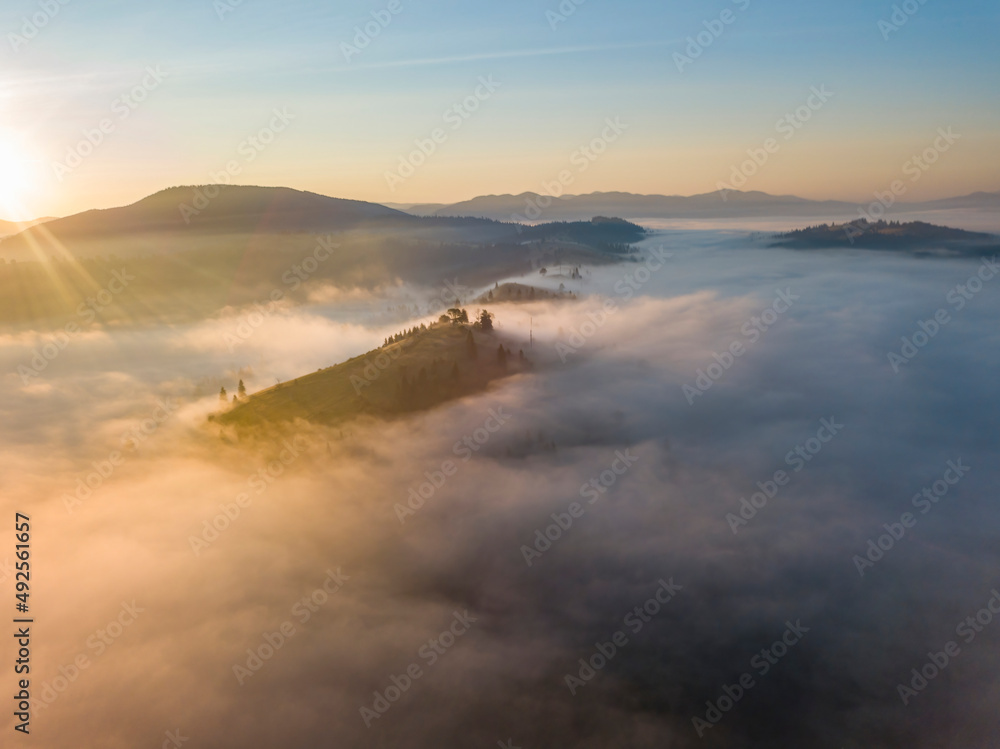 Fototapeta premium Sunrise over the fog in the Ukrainian Carpathians. Aerial drone view.