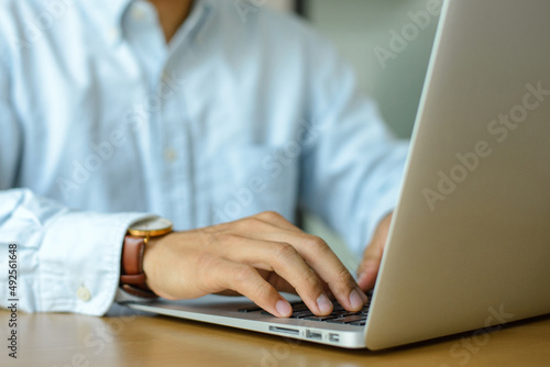 Young businessman working with laptop computer on desk.