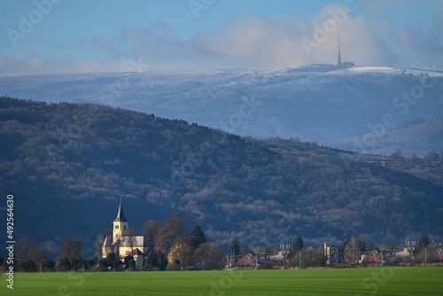 Church in the Slovak village Moravske Lieskove with a snowy peak Velka Javorina in the background photo