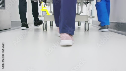 Doctors team pushing bed in hospital corridor