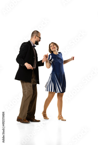 Couple of dancers, young man and woman in vintage retro style outfits dancing swing dance isolated on white background. Timeless traditions, 60s, 70s fashion style.