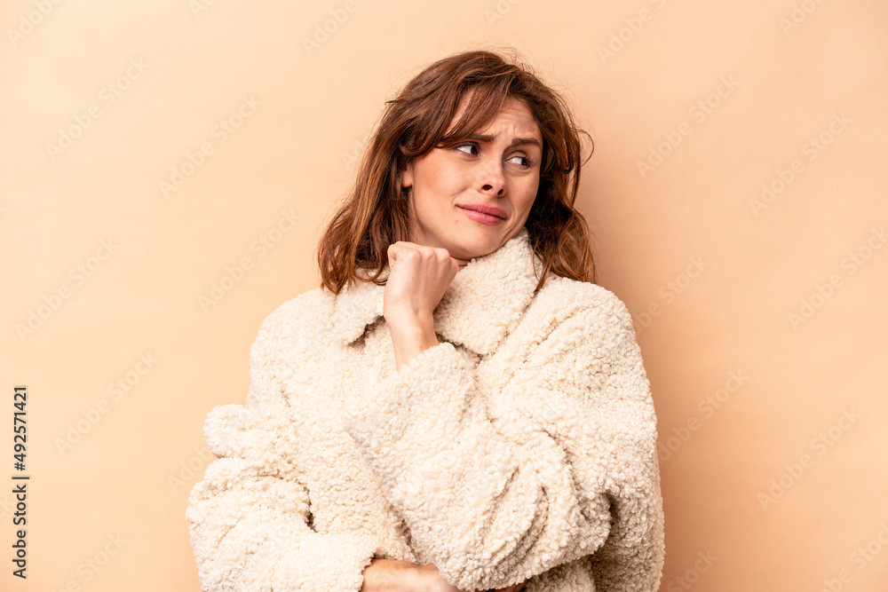 Young caucasian woman isolated on beige background confused, feels doubtful and unsure. Young caucasian woman isolated on beige background confused, feels doubtful and unsure.