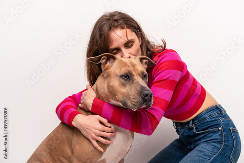 Young caucasian woman with her dog isolated on white background