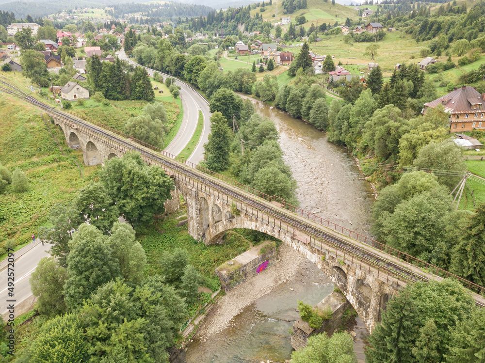 Fototapeta premium Old railway bridge in the mountains. Ukrainian Carpathians. Aerial drone view.