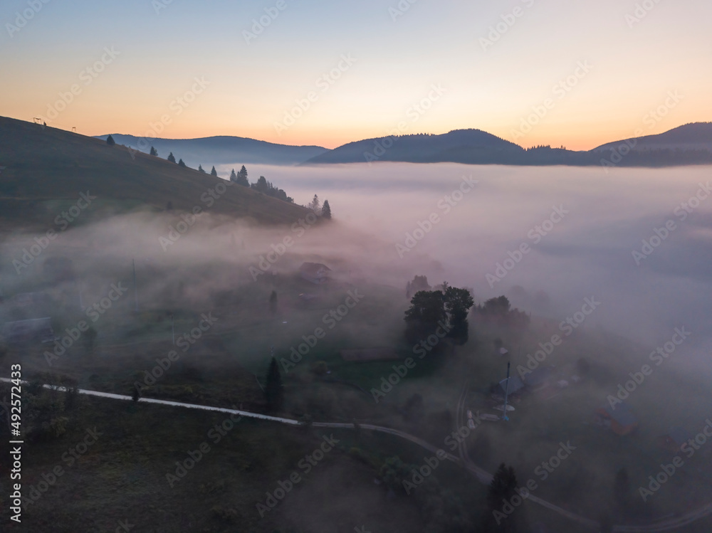 Fototapeta premium Sunrise over the fog in the Ukrainian Carpathians. Aerial drone view.