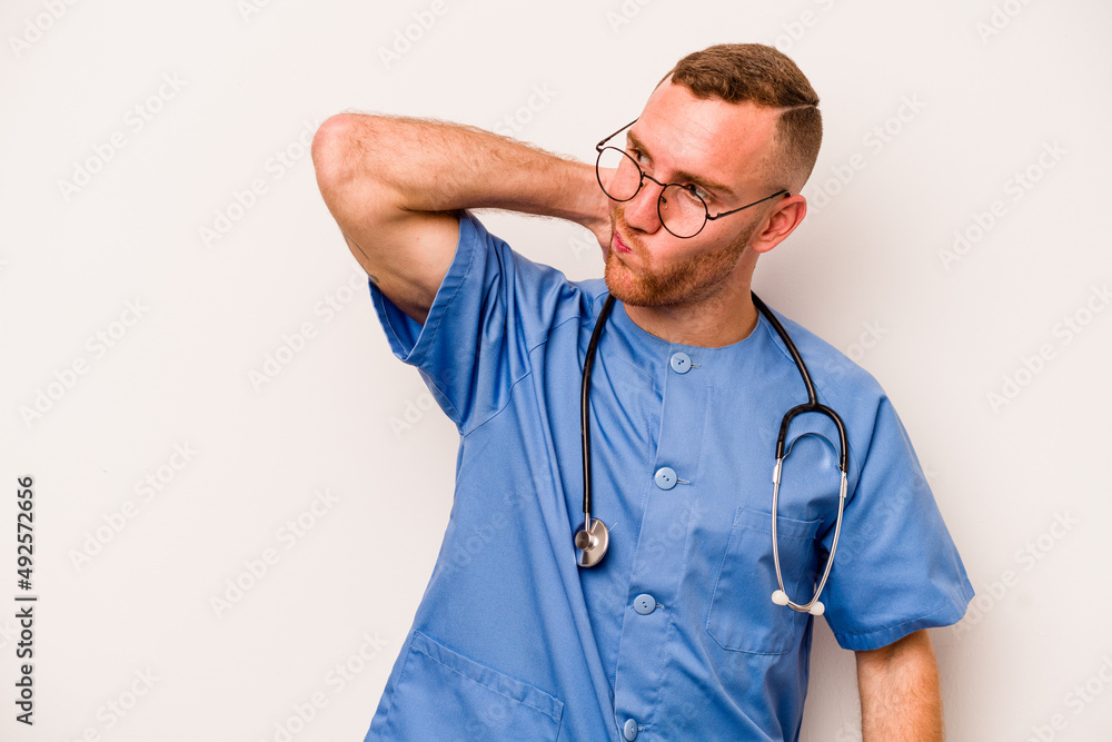 Young caucasian nurse man isolated on white background touching back of head, thinking and making a choice. Young caucasian nurse man isolated on white background touching back of head, thinking and making a choice.