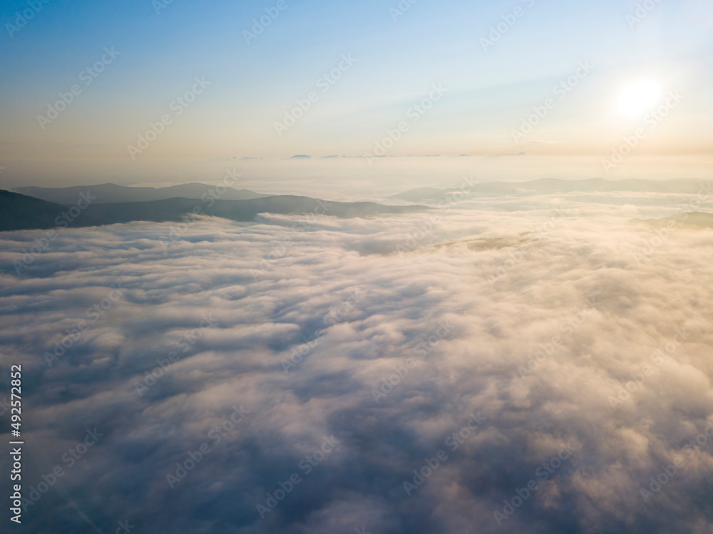 Flight over fog in Ukrainian Carpathians in summer. Mountains on the horizon. Aerial drone view. Flight over fog in Ukrainian Carpathians in summer. Mountains on the horizon. Aerial drone view.